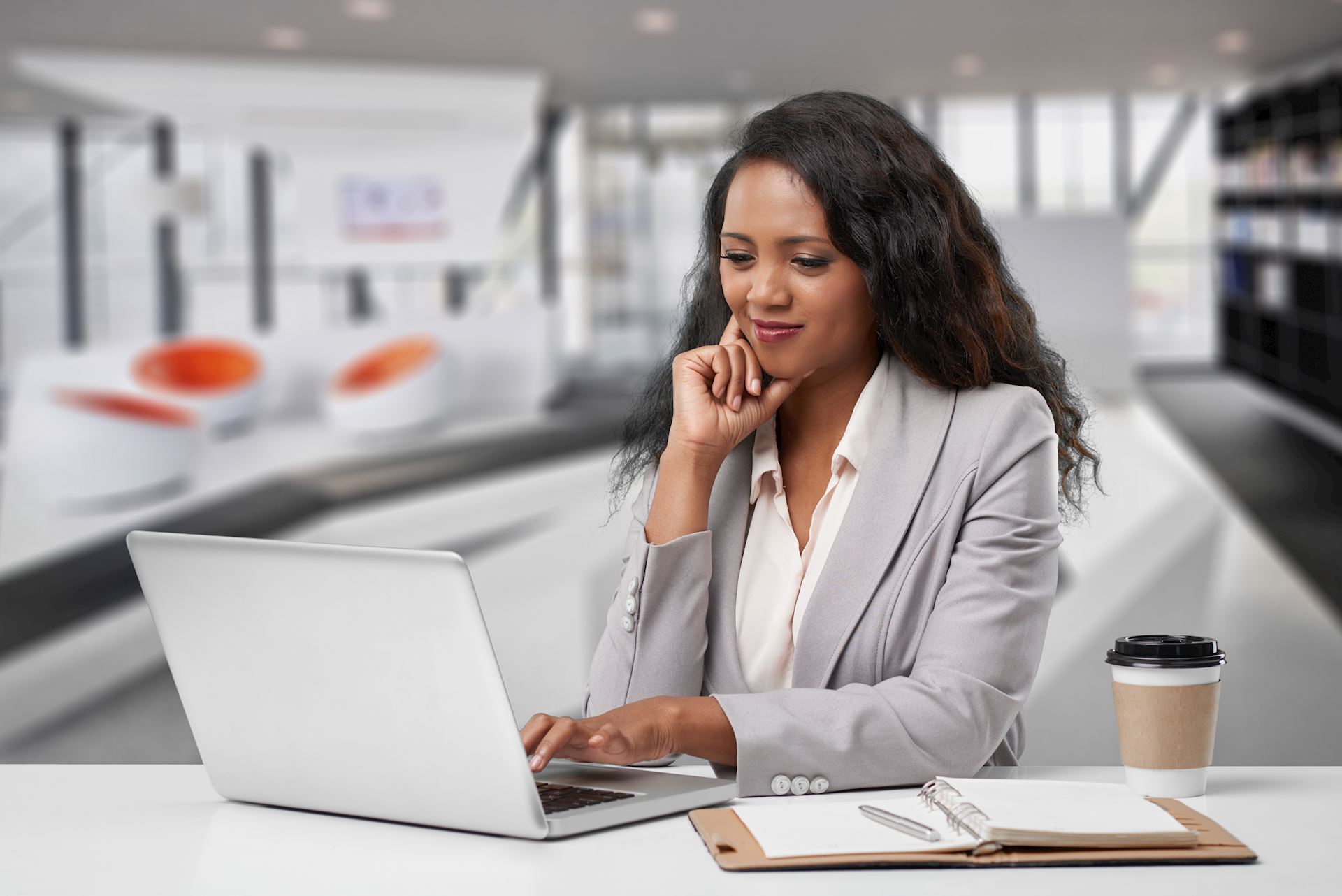 Woman in suit using a computer at trendy coffee shop