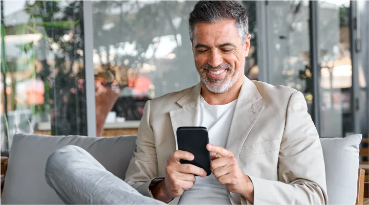 Man in business clothing smiling at phone